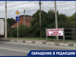 «Сделайте нам дорогу»: жители улицы Розовая устали обходить ямы