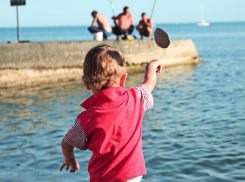 Дети кидают булыжники в плавающих новороссийцев
